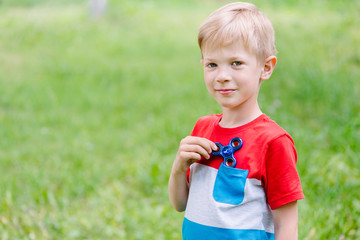 Teen boy playing a fidget spinner outdoors