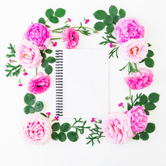 Floral frame of pink flowers and notebook on white background. Floral composition. Flat lay, top view.