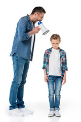 Fototapeta premium Father holding megaphone and screaming at little son standing isolated on white
