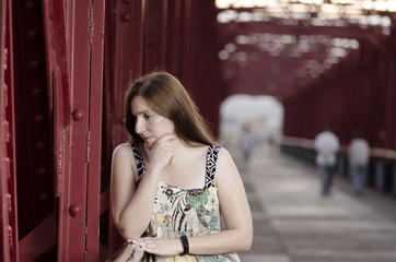 Beautiful woman standing on a red bridge over Ebro, Spain