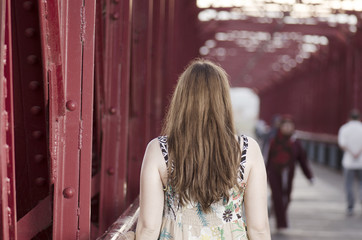 Fototapeta premium Back woman standing on a red bridge over Ebro, Spain