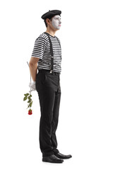 Sad mime with a rose waiting in line