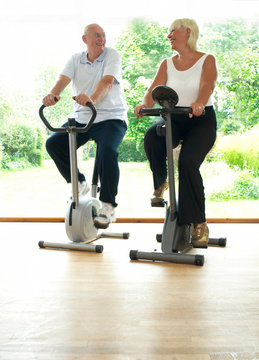 Older Couple Riding Stationery Bikes