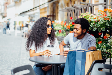 Young African American Couple In Love Drinking Coffee In City Street Cafe In Vacation Summer Time....