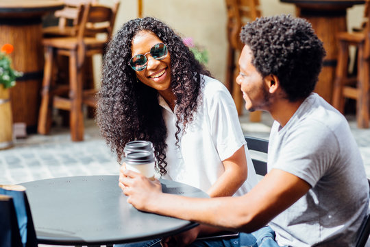 Young African American Couple In Love Drinking Coffee In City Street Cafe In Vacation Summer Time. Love Holiday and relationship concept