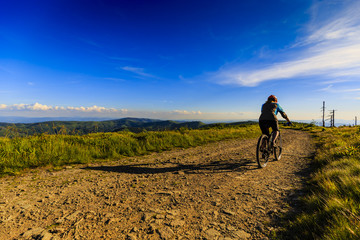 Mountain biking women riding on bike in summer mountains forest landscape. Woman cycling MTB flow trail track. Outdoor sport activity.