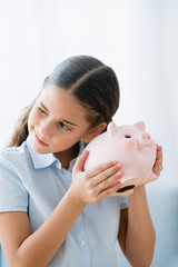 Fototapeta na wymiar Girl holding a piggy bank
