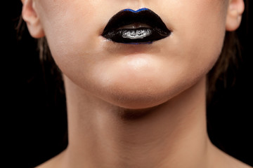 Close up of woman lips with black lipstick in studio photo. Beauty and fashion. Cosmetic and creative artistic make up