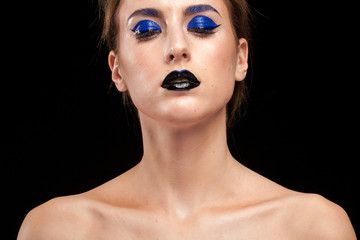 Beautiful woman wearing blue conceptual make up with black lips in studio photo. Beauty and fashion. Cosmetic and creative artistic make up