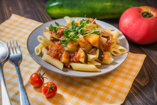 penne pasta plate meat and zucchini tomato sauce