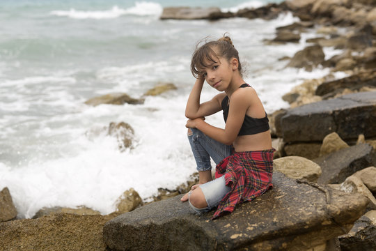 Little girl sitting on the rocks