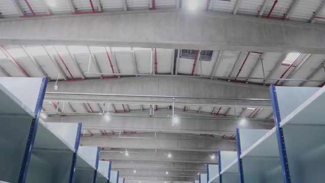 Stabilized movement between metal shelves with roof in industrial warehouse logistic