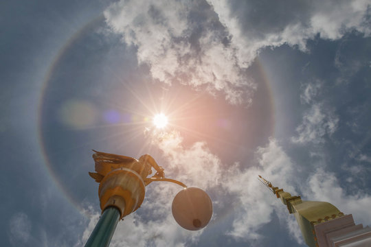 Abstract soft blurred and soft focus sun halo with the sanctuary, temple, beautiful sky cloud by the beam, light and lens flare effect tone.The public properties at Wat Phra That Tha Uthen, Thailand.