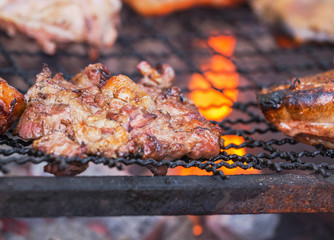 Close up barbecue pork roasting on charcoal grill with bright flame 