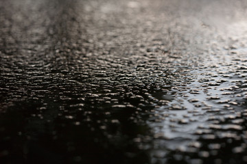 Wet asphalt sidewalk background after heavy rain soft focus.