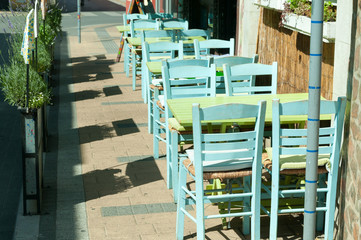 Empty wooden tables and chairs of coffee shop on the street. Selective focus.