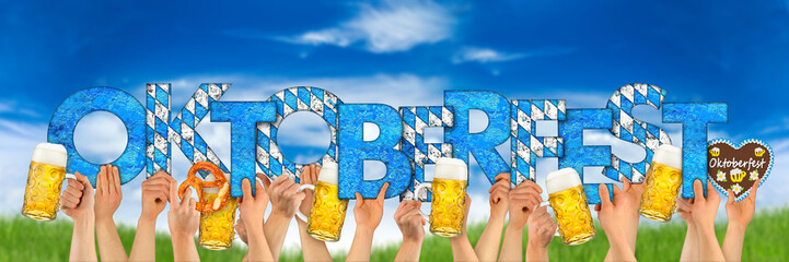 hands holding up beer mugs and oktoberfest letters in front of blue sky / Hände mit bierkrügen...