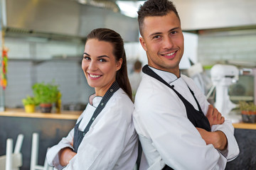Two smiling chefs in kitchen

