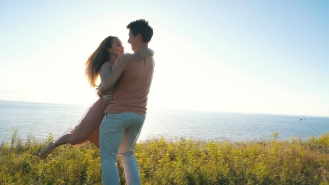 happy couple dancing at the edge of the cliff on the background of the river
