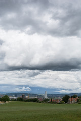 Fototapeta na wymiar Stadt mit Turm und dunklen Wolken - Hochformat