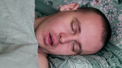 Fototapeta na wymiar Close-up shot of young man in bed at home sleeping.