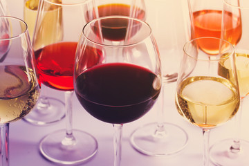 Set of party glasses with red, white and rose wine close up, retro toned