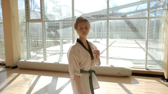 Young woman training the karate tricks in the gym