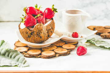 Fresh strawberry on coconut cup and strawberry sauce. Marble background.Toning.