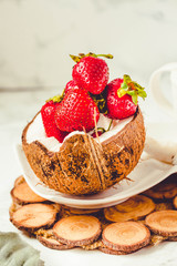 Fresh strawberry on coconut cup. Marble background.Toning.