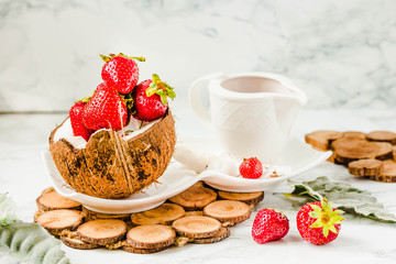 Fresh strawberry on coconut cup and strawberry sauce. Marble background.Copy space.