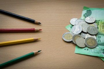 Pencil and money on a wooden  using wallpaper or background for  business work.