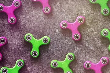 Fidget finger spinner green and pink stress anxiety relief toy on dark background