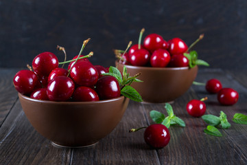 Fresh cherries in  clay bowl on  dark table