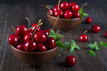 Fresh cherries in  clay bowl on  dark table