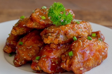 Barbecue chicken wings on white plate served with barbecue dipping sauce. Homemade bbq chicken wing delicious,moist and spicy. Barbecue chicken wing served with chili sauce or tomato sauce(ketchup).