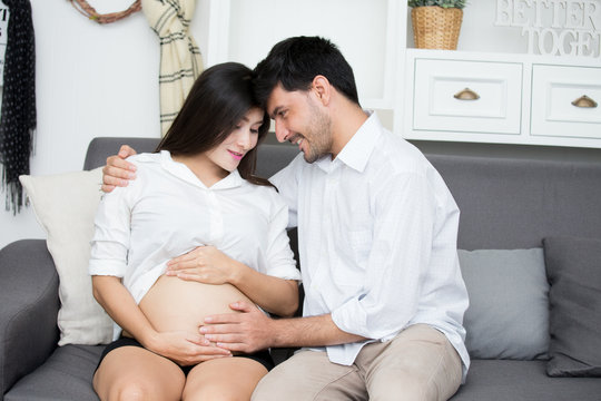 Asian pregnant woman and husband with happy emotion together at home.