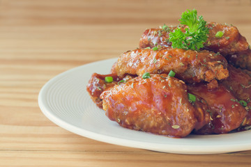 Barbecue chicken wings on white plate served with barbecue dipping sauce. Homemade bbq chicken wing delicious,moist and spicy. Barbecue chicken wing served with chili sauce or tomato sauce(ketchup).