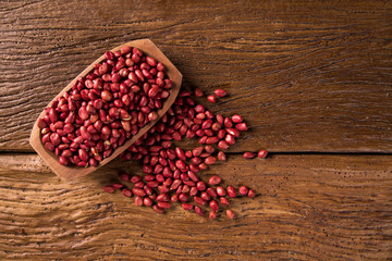 Raw peanuts in wood bowl.
