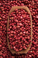 Raw peanuts in wood bowl.