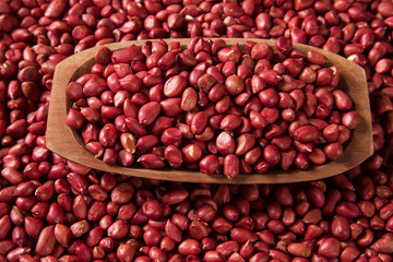Raw peanuts in wood bowl.