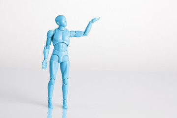 Blue male figurine standing on white reflective table holding one hand up. Making a decision concept with copy space