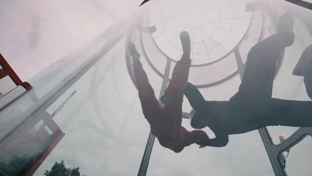 Skydivers tandem fly into wind tunnel. Extreme parachuting