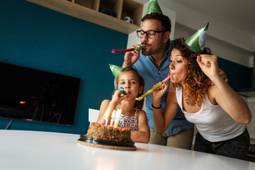 Daughter's birthday.Mom and dad surprise they daughterwith birthday cake .