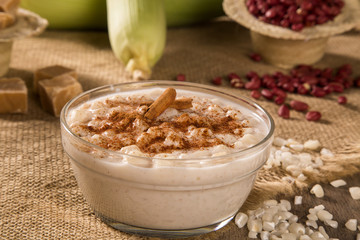 Brazilian dessert canjica of white corn with cinnamon in transparent plate.