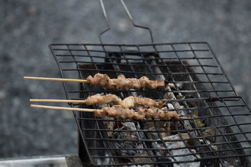 Roasted pork on a charcoal stove.