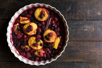 Grilled berries and peaches on wooden background with blank space