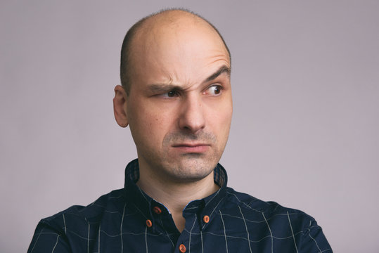 Serious bald man with raised eyebrow