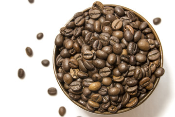 Top view of a wooden cup of fragrant coffee beans on a white background