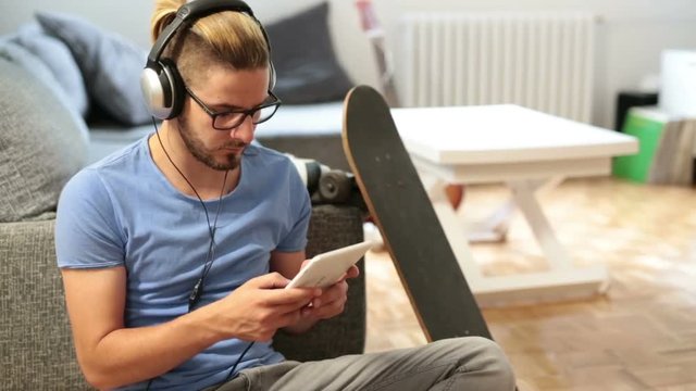Man listening music on tablet at his home