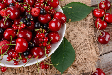 Mature berries on a plate on a wooden table